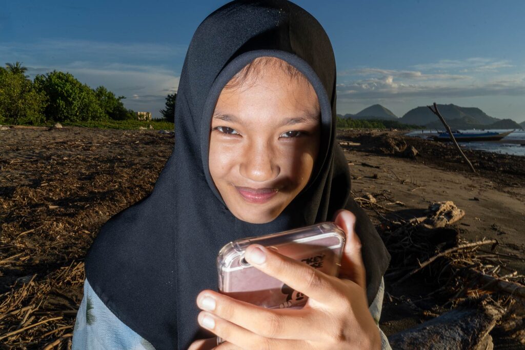 girl with phone on beach