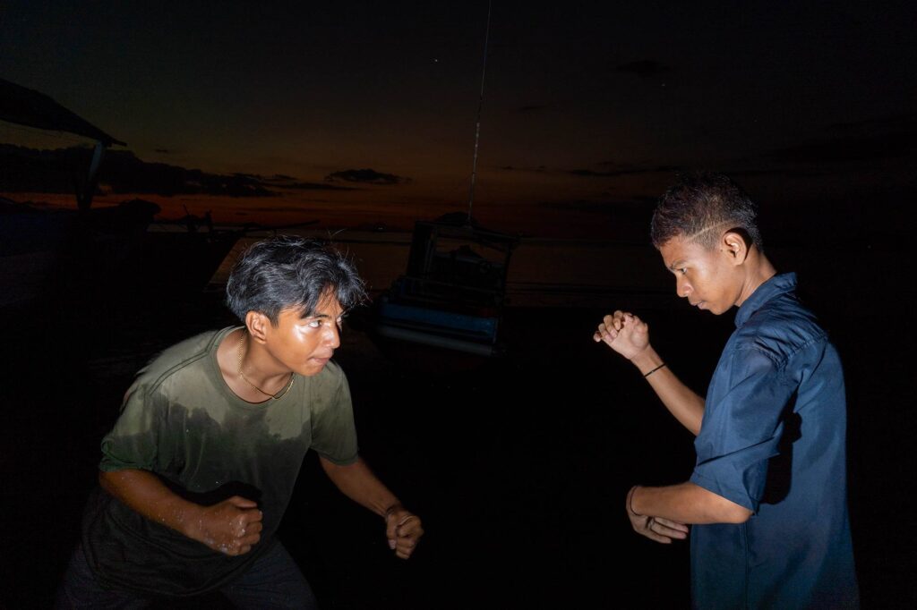 two boys boxing on the beach